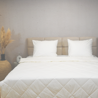 Off white HappyBed Premium percal cotton summer duvet on bed with white pillows in minimalist bedroom