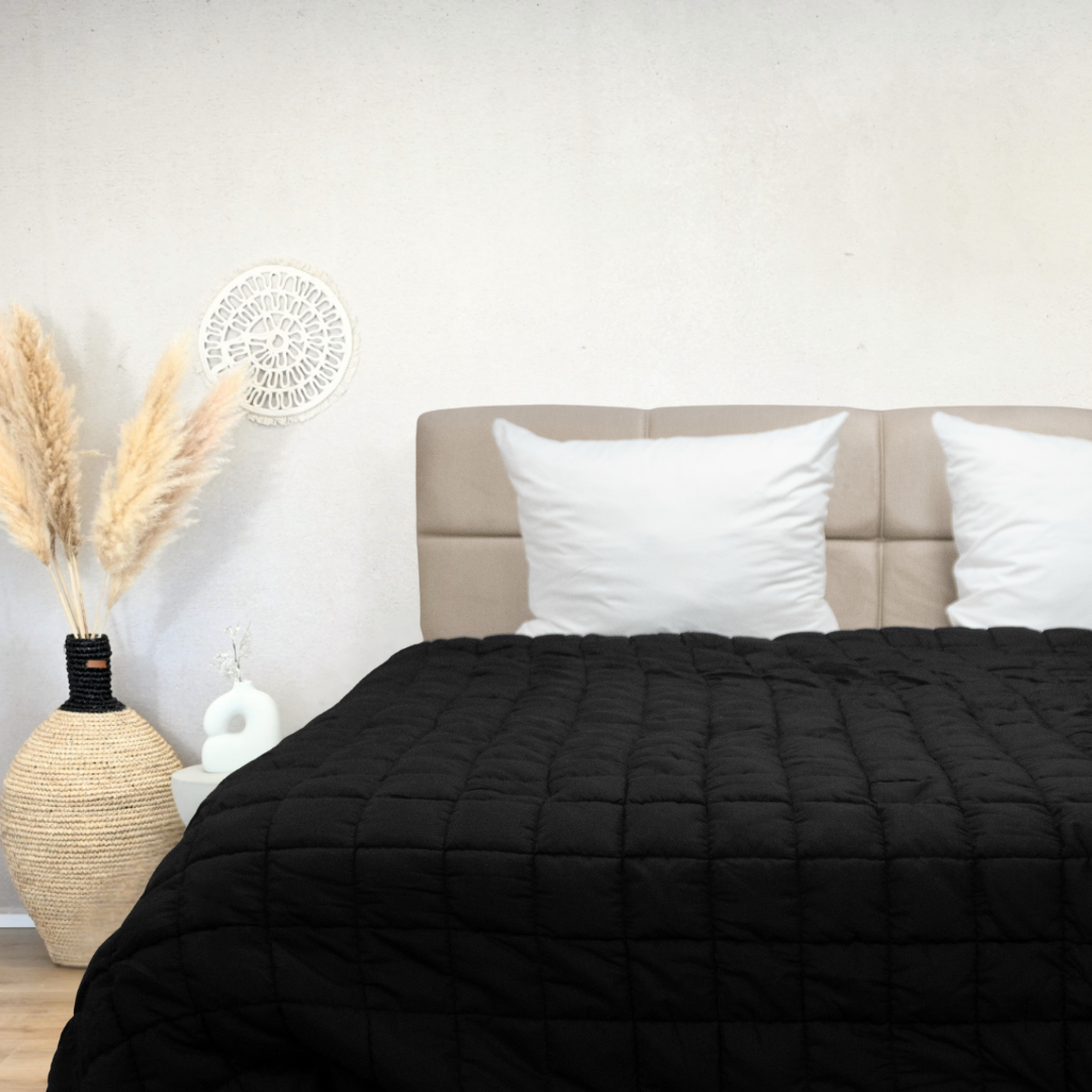 Black HappyBed Puffy dekbed on bed with beige headboard and white pillows in modern bedroom setting