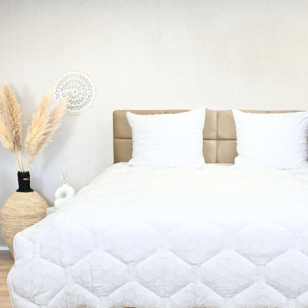 HappyBed Tufted Frosty White duvet on a bed, featuring a tufted design and cozy microfibers, suitable for all seasons.