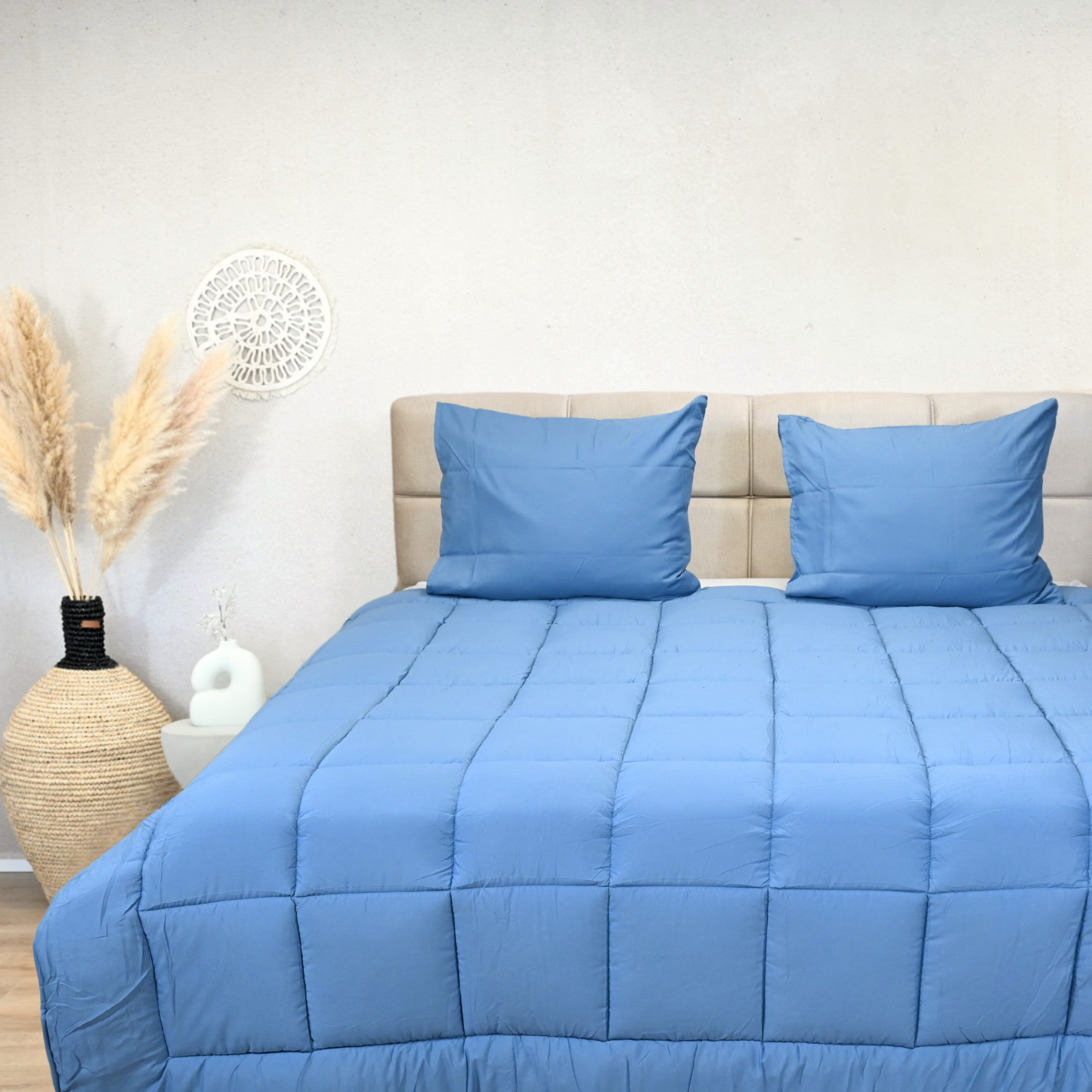 HappyBed Bluestone all-season bedstead with blue cover and matching pillows in a cozy bedroom setting.