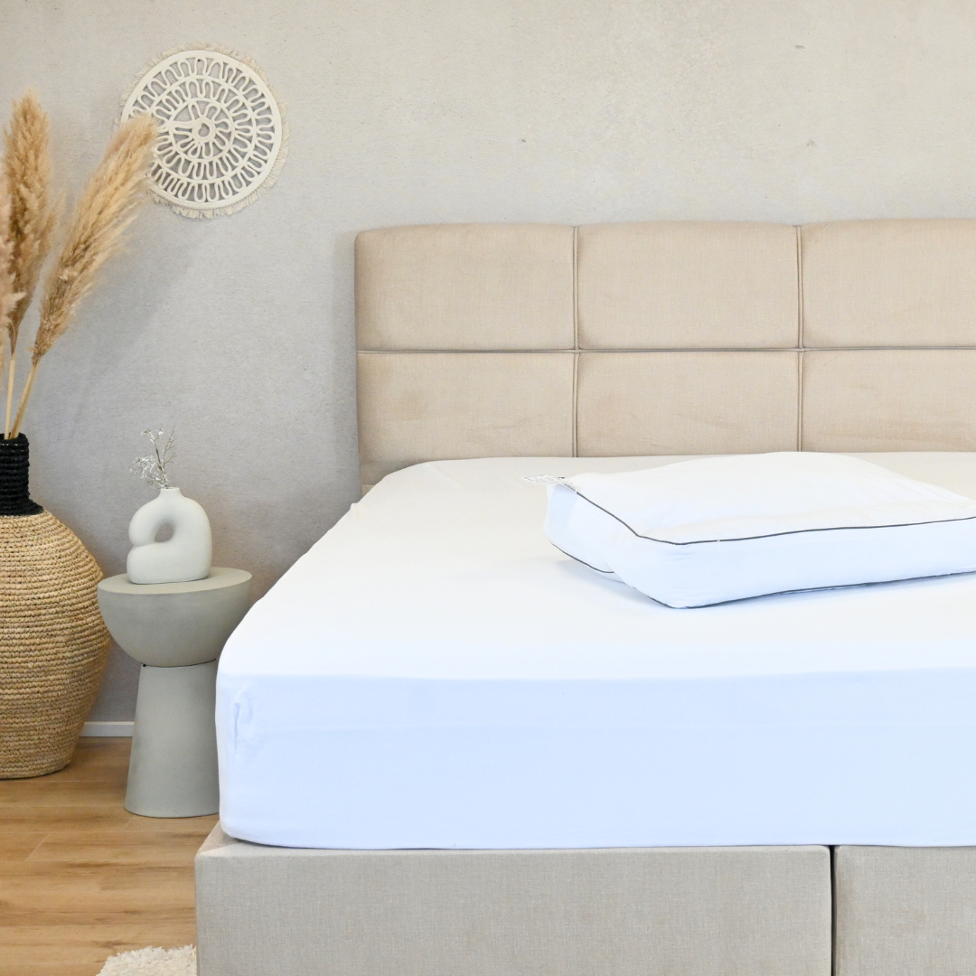 60x50 cm nek ondersteunend kussen op bed met lichte kleur muren en moderne inrichting.