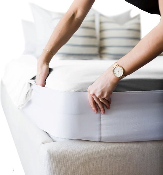 Person using the HappyBed Lakenspanner to secure a bedsheet neatly on a mattress.