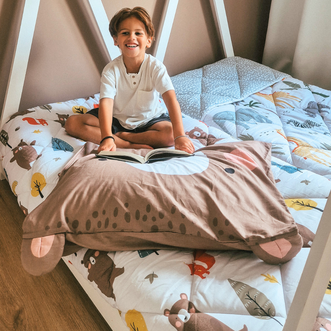 HappyBed Kids - Bobby Bear 100% cotton year-round duvet, child smiling on bed with bear-themed bedding.