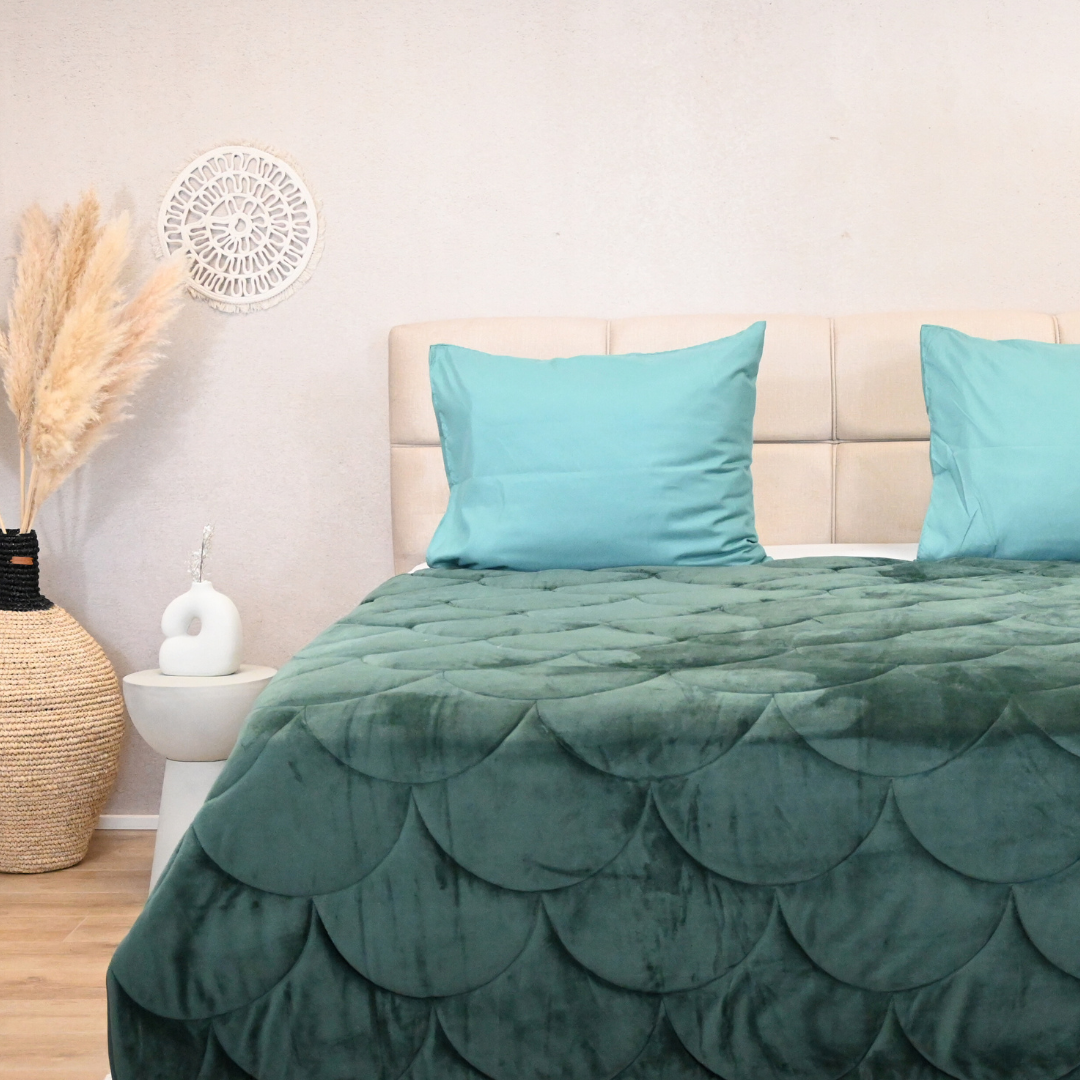 HappyBed velvet dark green all-season duvet on bed with blue pillows.