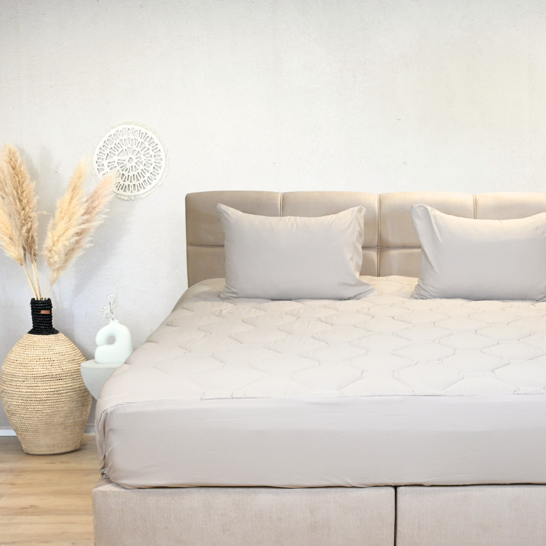 HappyBed Taupe dekbed op opgemaakt bed met kussens, perfect voor elk seizoen.