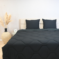 Black HappyBed Mousseline dekbed on a bed with matching black pillows in a modern bedroom setting