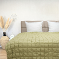 Puffy dekbed Pistache in light green on bed with beige headboard and white pillows in cozy bedroom setting