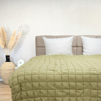 Puffy dekbed Pistache in light green on bed with beige headboard and white pillows in cozy bedroom setting