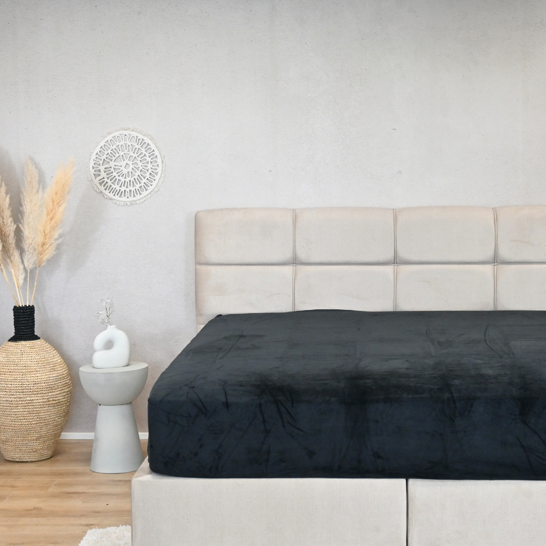 HappyBed premium velvet hoeslaken in black on a stylish bed featuring premium jerseykatoen fabric with wrinkle-free fit.