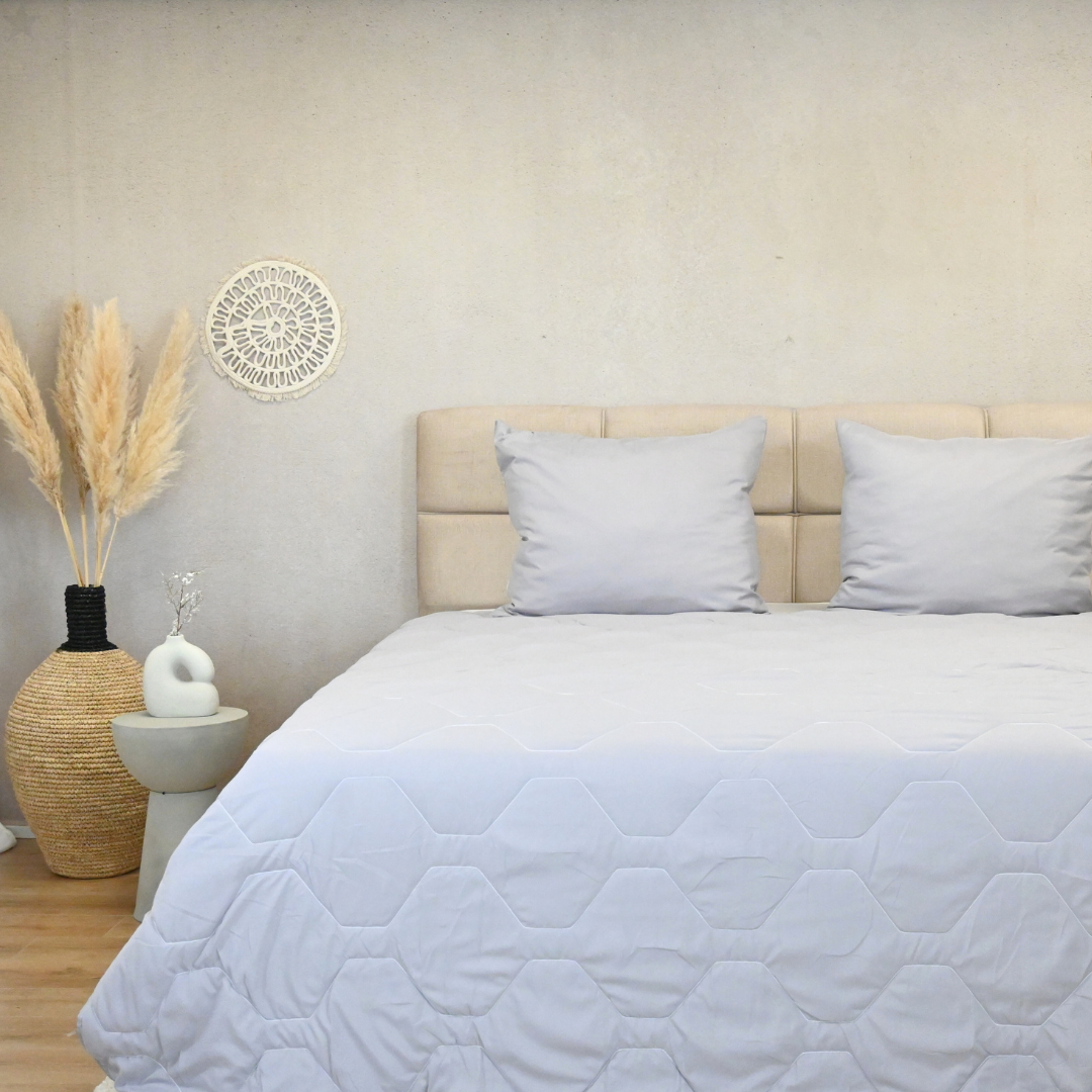 HappyBed Grey summer duvet for warm nights on bed with decorative pillows.