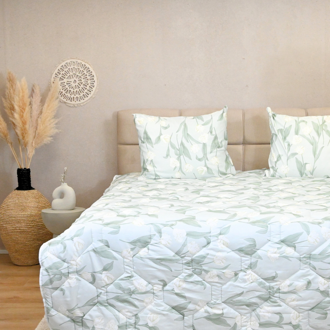 White roses satin-look duvet on bed with matching pillows.