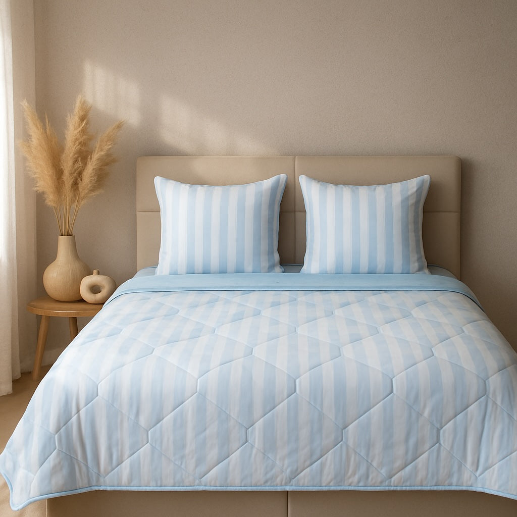 Light blue HappyBed zomerdekbed on a bed, featuring a soothing and elegant design for cooling comfort during warm nights.