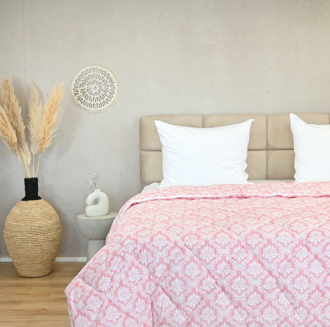 HappyBed Pink elegance all-season duvet on a bed with pillows and decorative elements in a cozy bedroom setting.