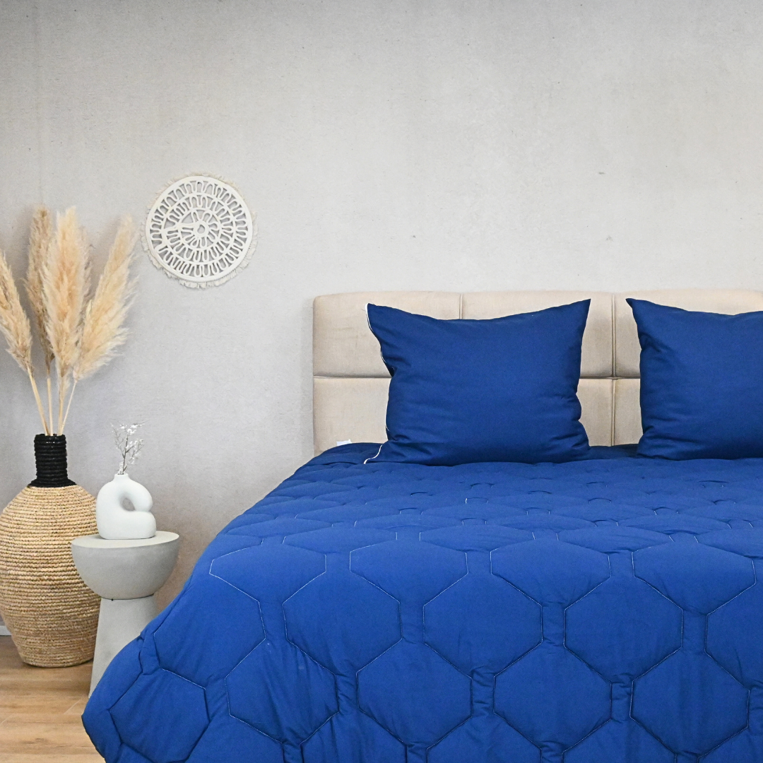 HappyBed Navy adjustable 4-season duvet on bed with pillows in modern bedroom setting.