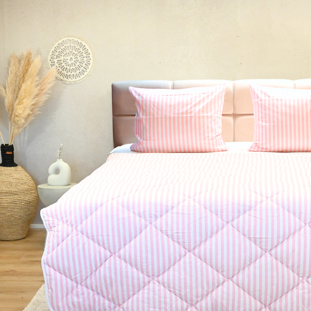 HappyBed Cotton Candy 100% katoen dekbed op een bed met roze gestreepte kussens.