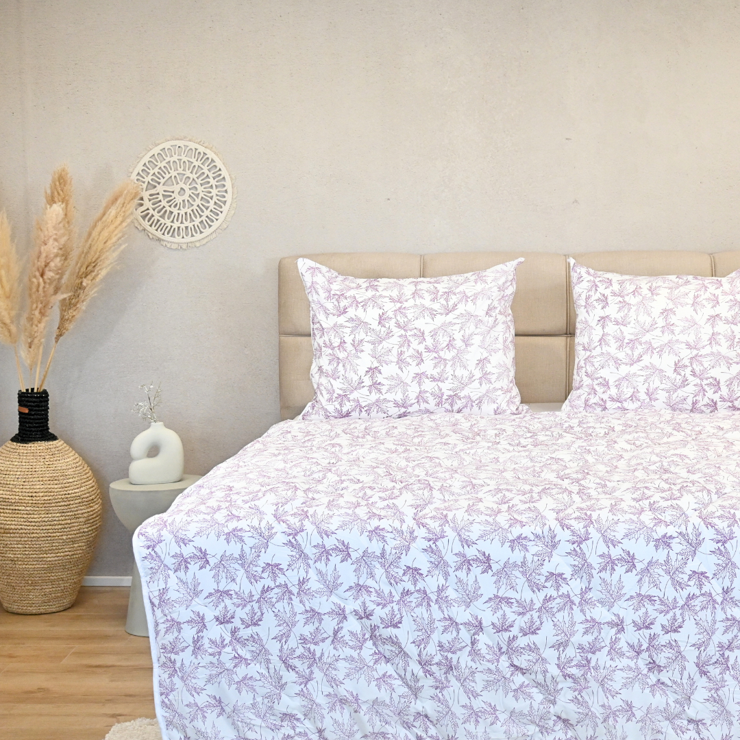 HappyBed Violet leaves all-season duvet on a bed with matching pillows in a serene bedroom setting.