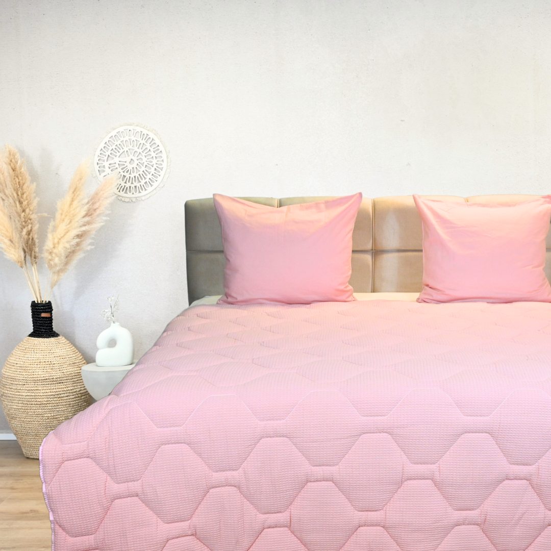 HappyBed Wafel Pink all-season duvet in pink, 100% cotton, on a bed with two pink pillows.